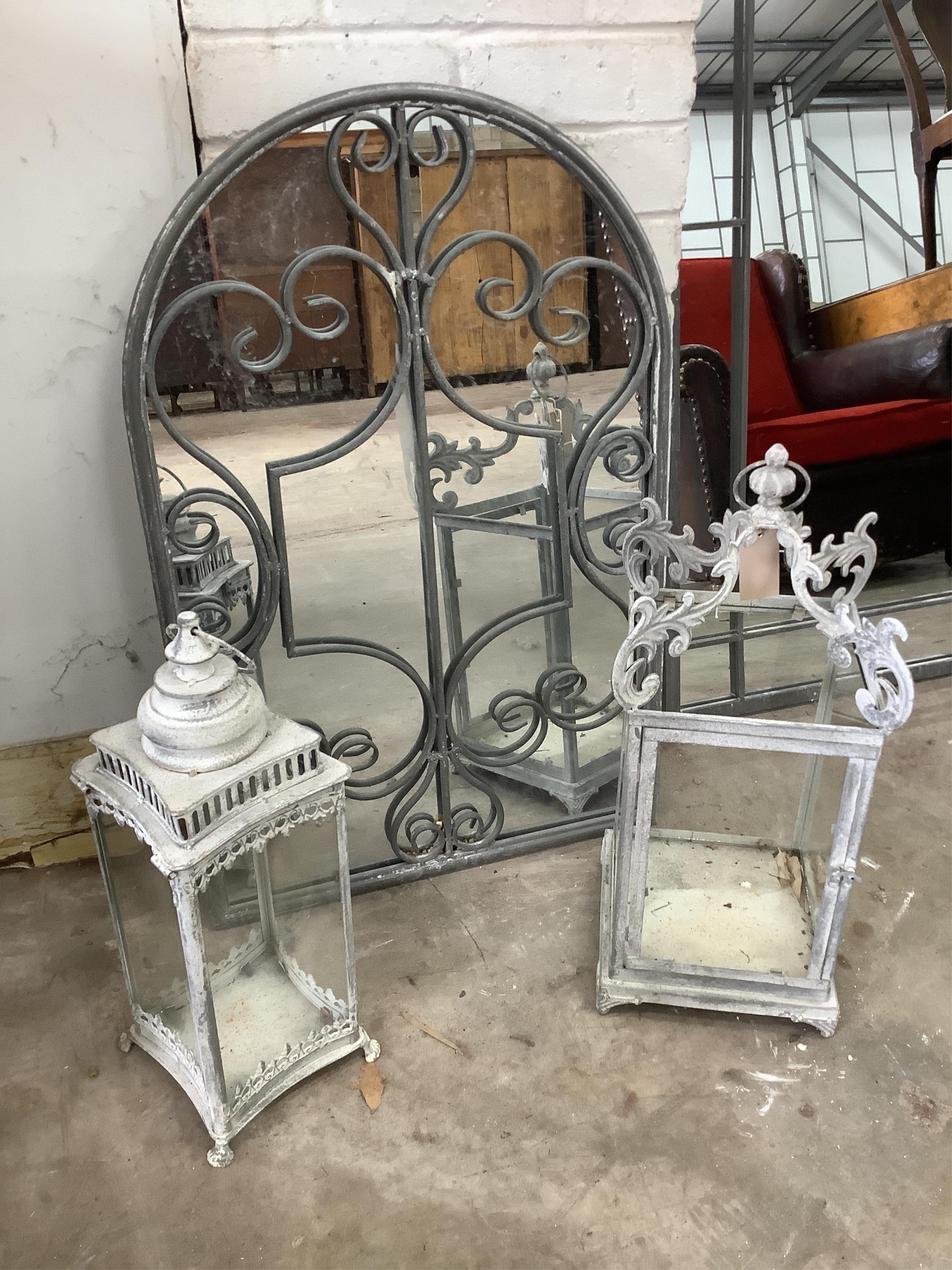 A cast metal garden wall mirror, width 50cm, height 77cm, together with two glazed metal lanterns. Condition - good